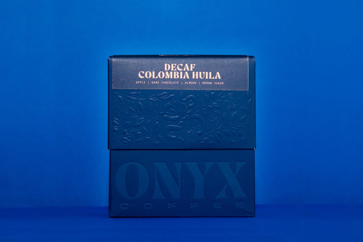 Decaf Colombia Huila coffee from Onyx Coffee Labs on a fruity green background